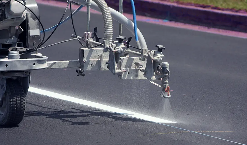 Marking machine marking lines on asphalt pavement